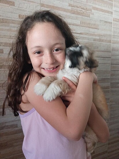Gabriela holding Bento when he was a puppy.