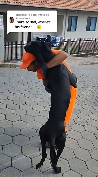 The dog hugs the man.