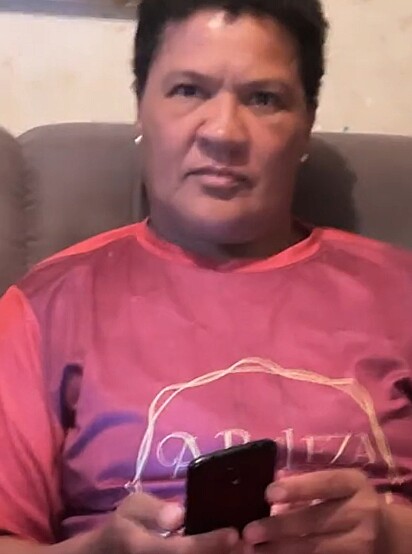Josiane was sitting on the couch, scrolling through her phone.